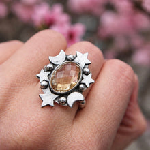 Cargar imagen en el visor de la galería, Anillo Astra de citrino ovalado en plata con estrellas y lunas, puesto en la mano